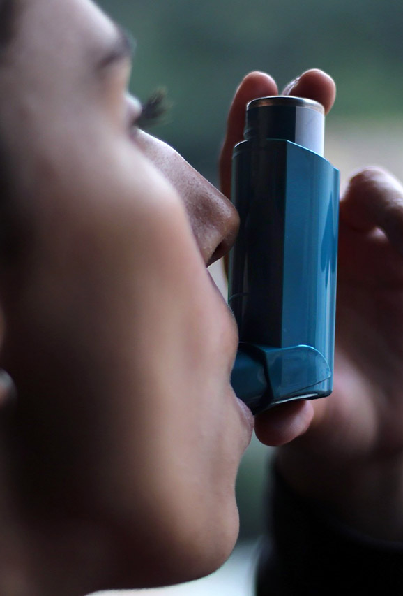Photo of a woman with asthma using an inhaler